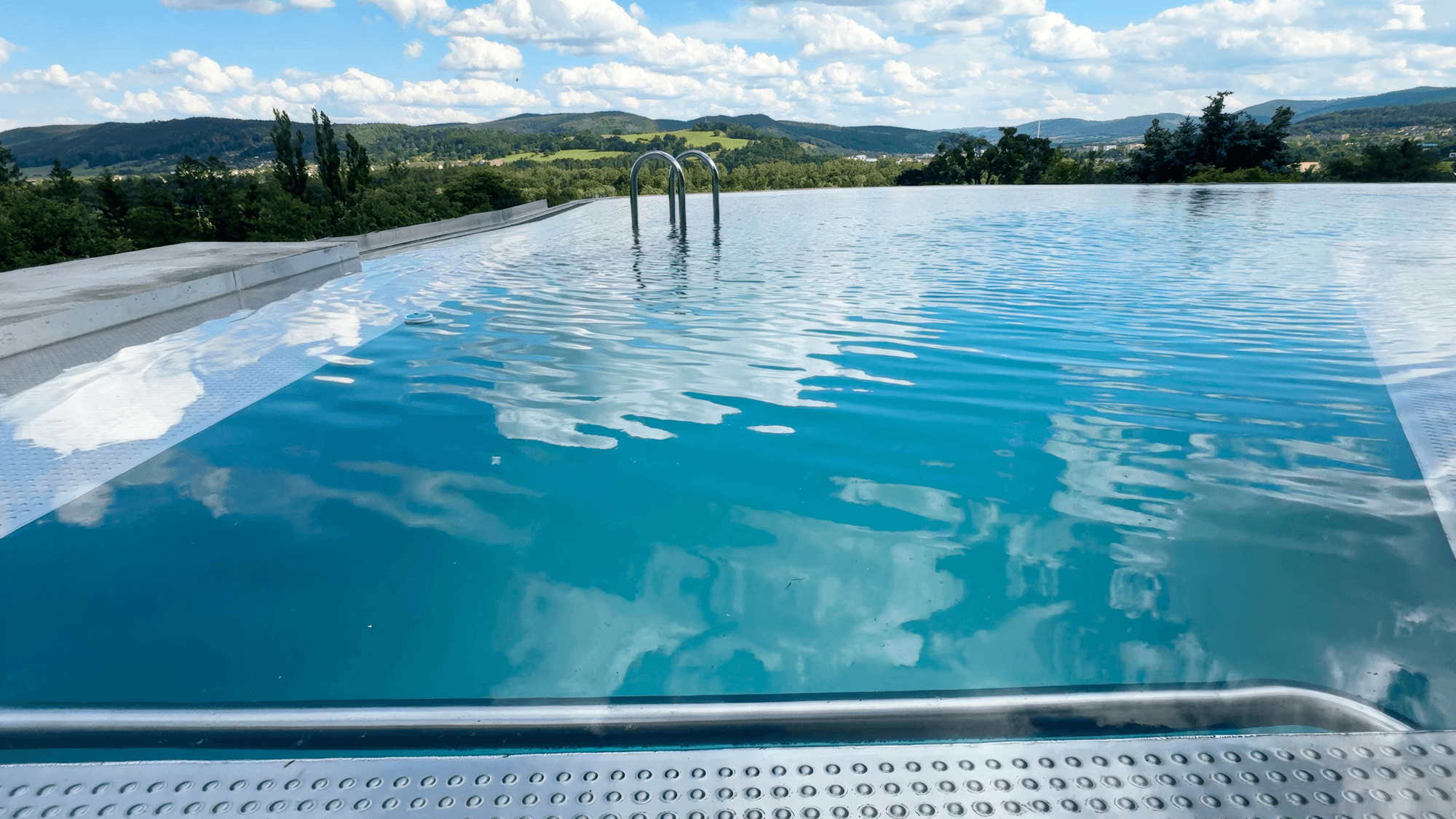 Nerezový infinity bazén Almark Pools s výhledem do krajiny